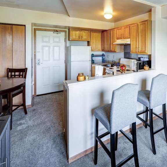 a kitchen with a white fridge and wooden cabinets.