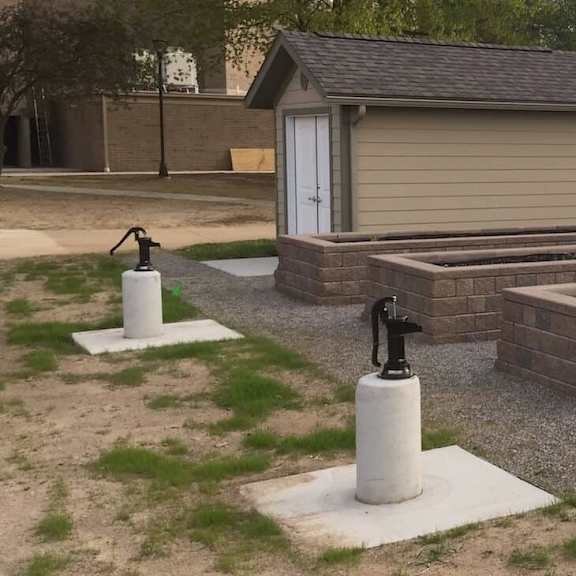 a garden with a small building and raised beds.
