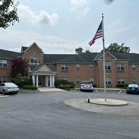 a parking lot in front of a building with a flag on top.