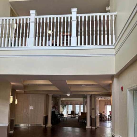 a large open living room with a balcony and hardwood floors.