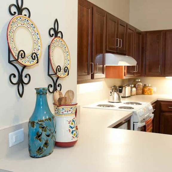 a kitchen with a white counter top and a blue vase.