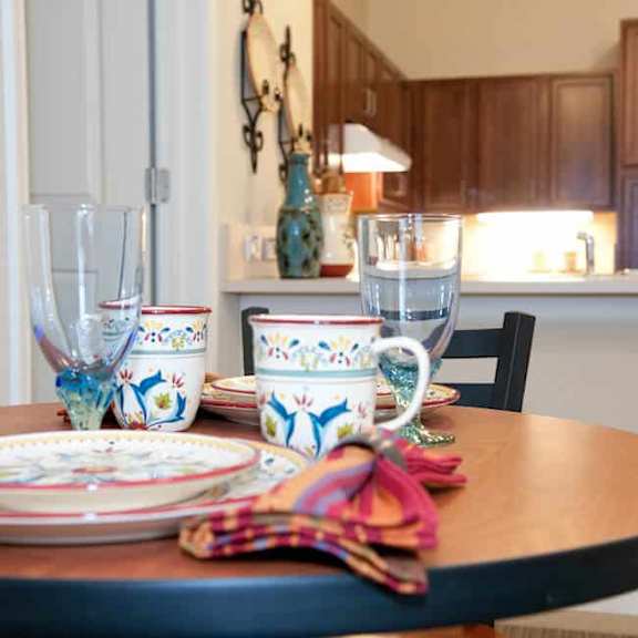 a table set with plates, glasses, and a cup.