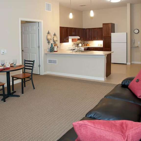 a kitchen with a table and chairs in front of it.