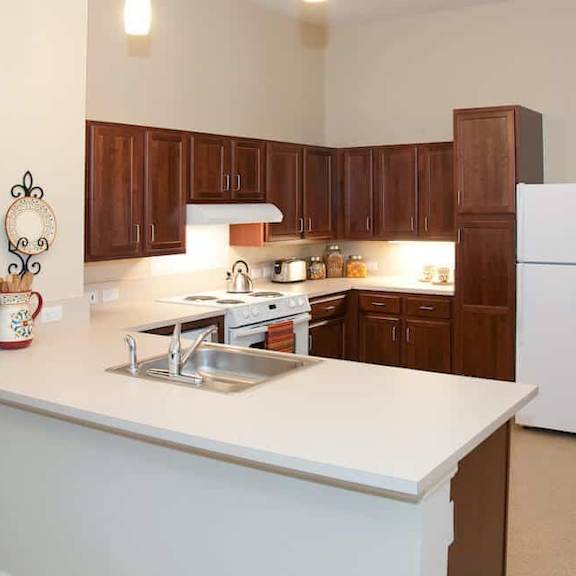 a kitchen with brown cabinets and a white counter.