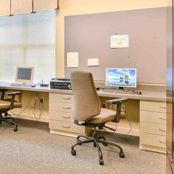 a room with a desk and chairs.