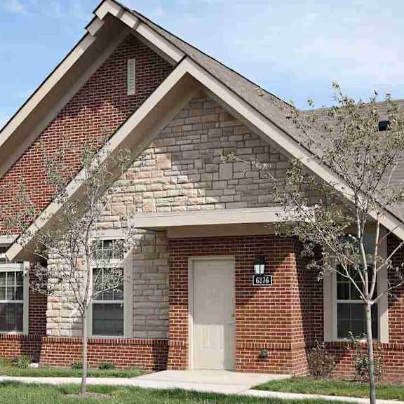 a brick house with a white door and windows.