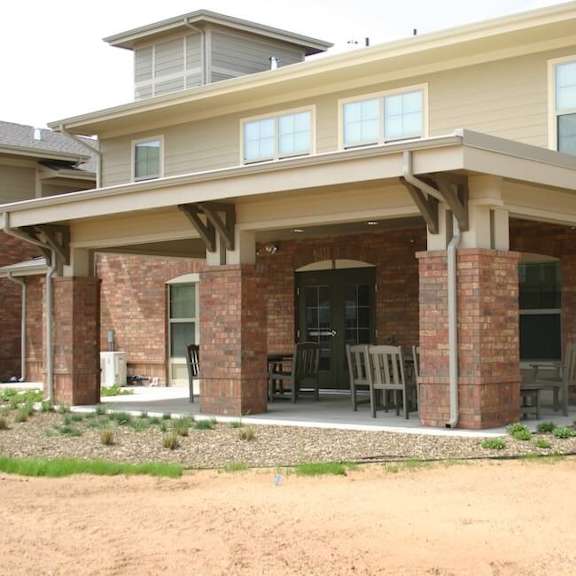 a house with a covered patio and a brick wall.