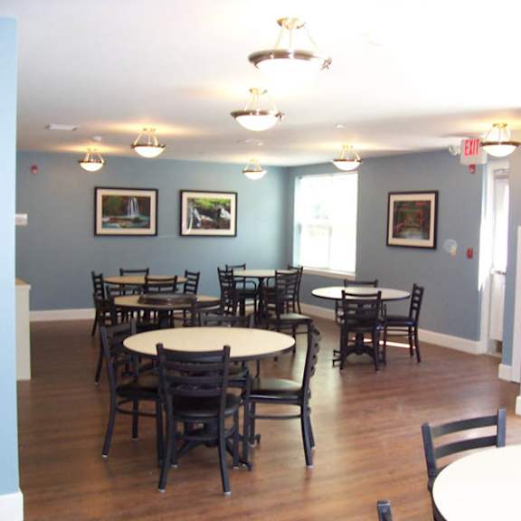 a room with tables and chairs and pictures on the wall.