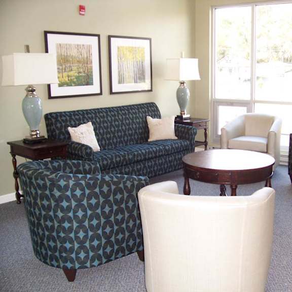 living room with a couch, chair, ottoman, and lamp.