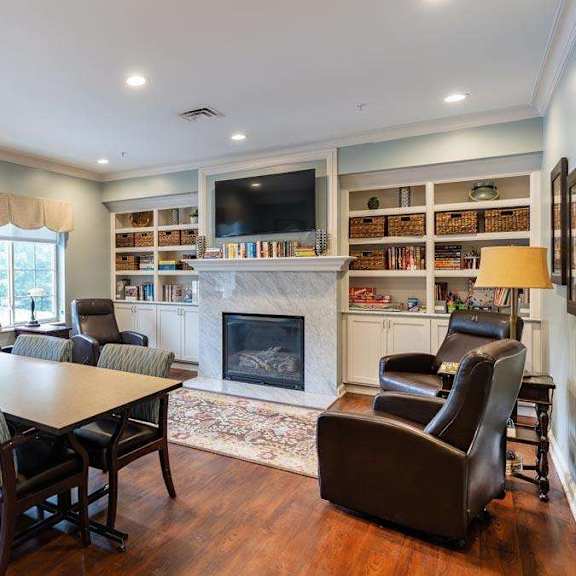 a living room with a fireplace and a tv on the wall.