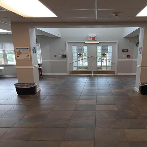 a hallway with a red exit sign above the door.