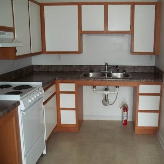 a kitchen with a white stove and wooden cabinets.