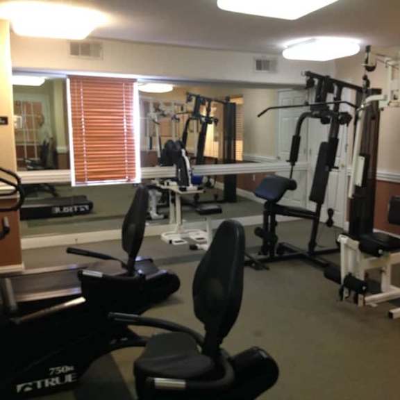 a gym with a variety of equipment including weights and machines.