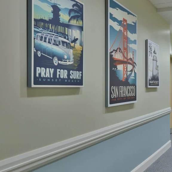 a hallway with posters on the wall and a carpeted floor.