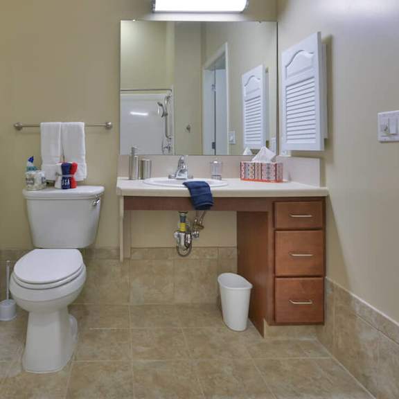 a bathroom with a toilet, sink, and towels.