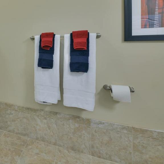 a bathroom with a white shower curtain and two towels hanging on the wall.