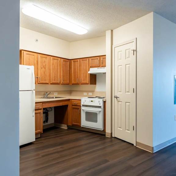a kitchen with wooden cabinets and a white refrigerator.