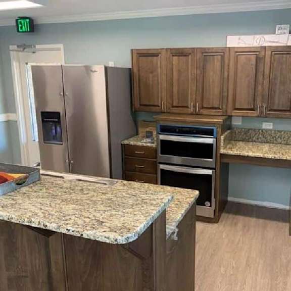 a kitchen with a granite counter top and wooden cabinets.