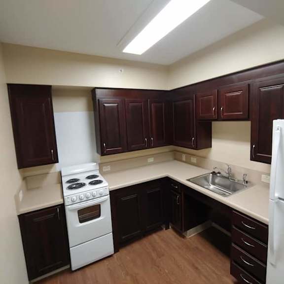 a kitchen with dark brown cabinets and a white stove top oven.