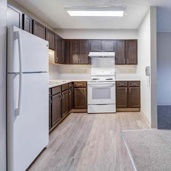 a kitchen with a white fridge and wooden cabinets.