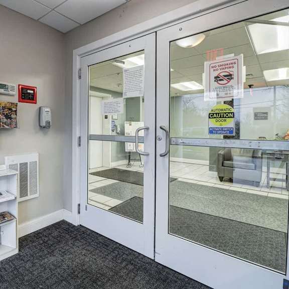 a white door with a glass window and a sign that says "caution door".