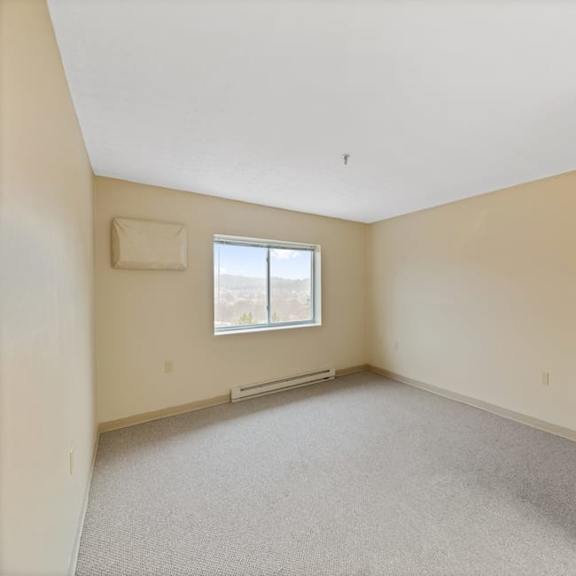 a room with a window and a picture on the wall.