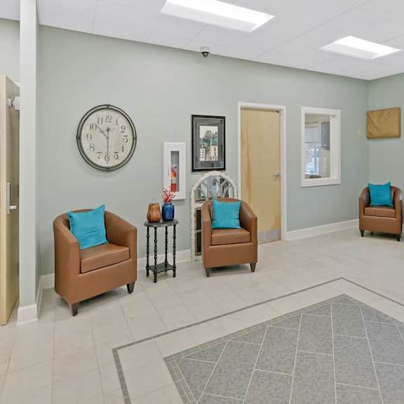 a waiting room with two chairs and a clock on the wall.