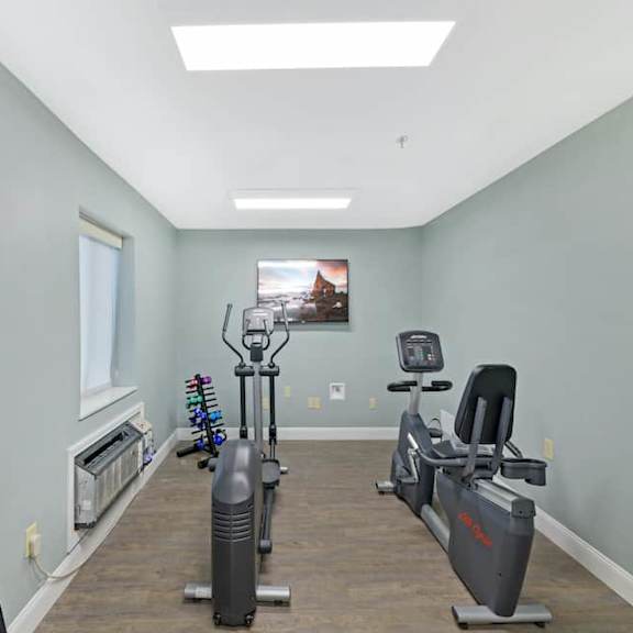 a room with a treadmill, exercise bike, and other fitness equipment.