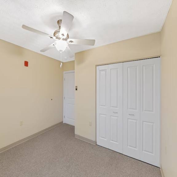 a room with a ceiling fan and two doors.