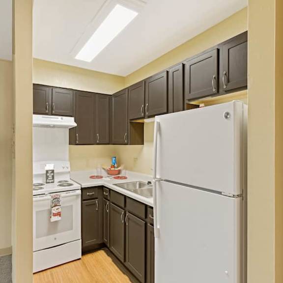 a kitchen with a white refrigerator and a white stove with a white oven.