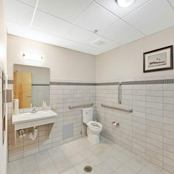 a bathroom with a toilet, sink, and mirror.