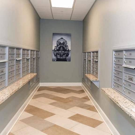 a long hallway with mailboxes on both sides and a picture of a train in the middle.