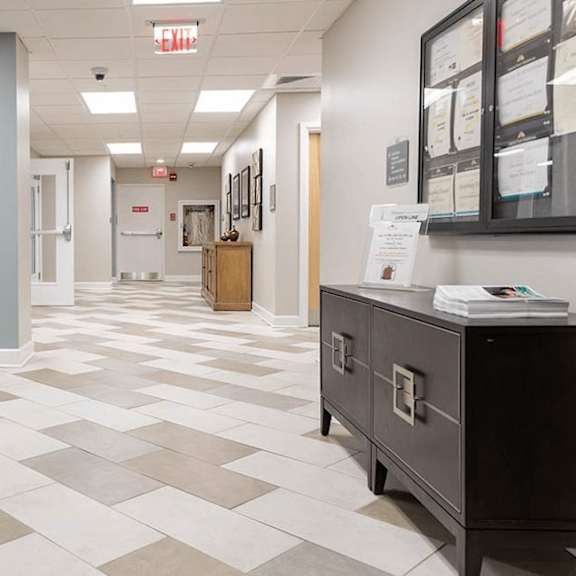a hallway with a black and white checkered floor and a black filing cabinet.
