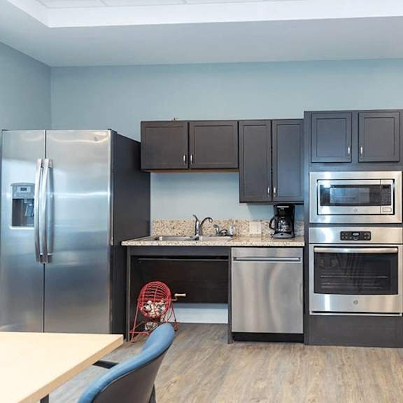 a kitchen with a refrigerator, oven, and microwave.