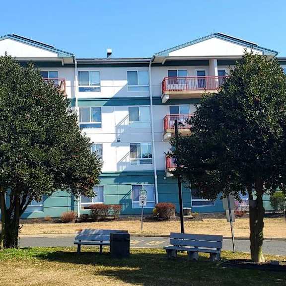 a large apartment building with a green lawn in front.