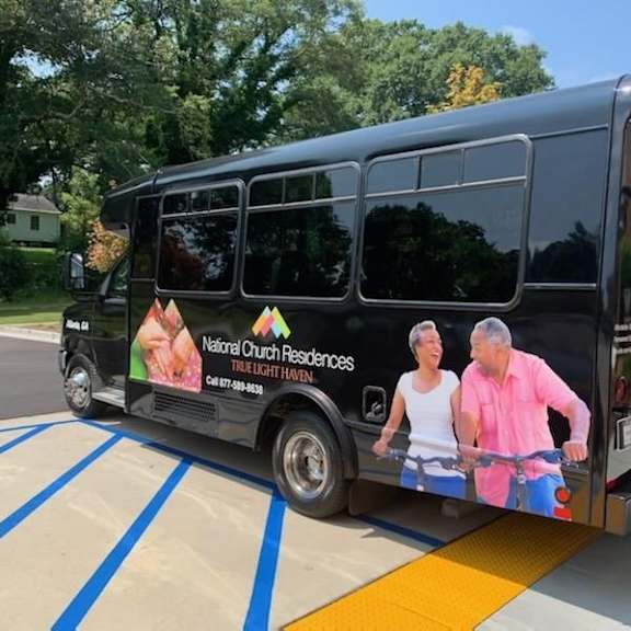a black bus with an advertisement for national church residences on the side.
