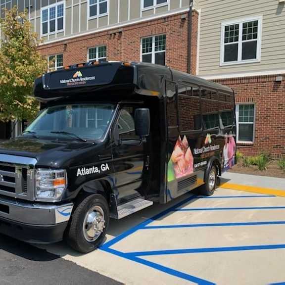 a black truck with a wrap advertising women's health is parked in a parking lot.