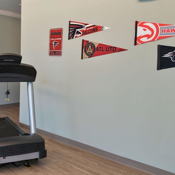 a treadmill is in a room with a wall of flags.