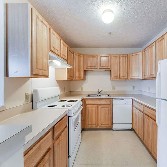 a kitchen with wooden cabinets and white appliances.