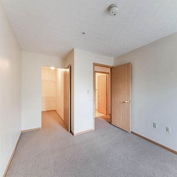 a room with carpeted floor and two open doors.