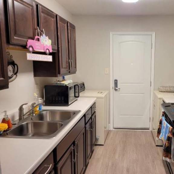 a kitchen with a black fridge and a white door.