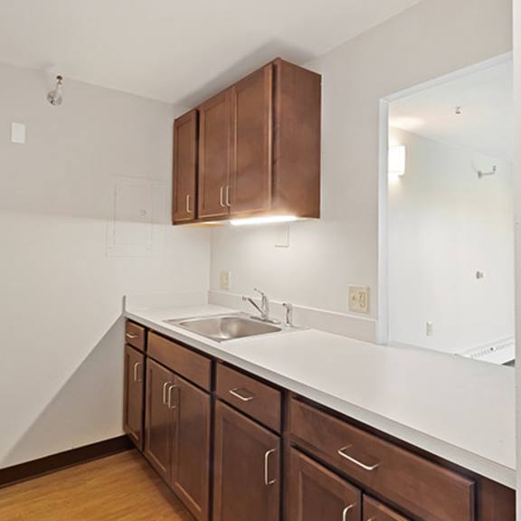 a kitchen with brown cabinets and a white fridge.