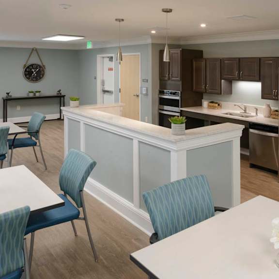 a kitchen with a table and chairs in front of it.