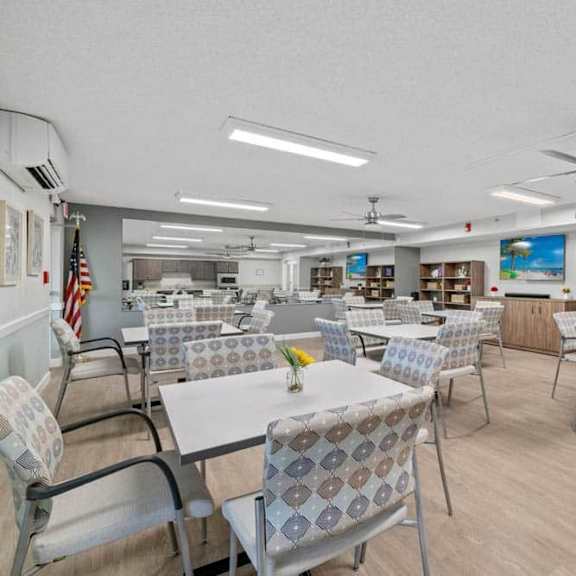a room with tables and chairs and a ceiling fan.