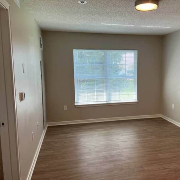 a room with a window and wooden flooring.