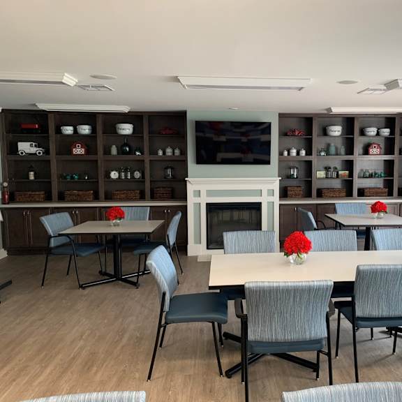a dining room with a white table and grey chairs.