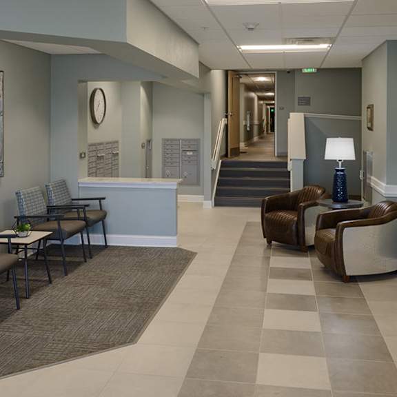a hallway with a row of chairs and a painting on the wall.