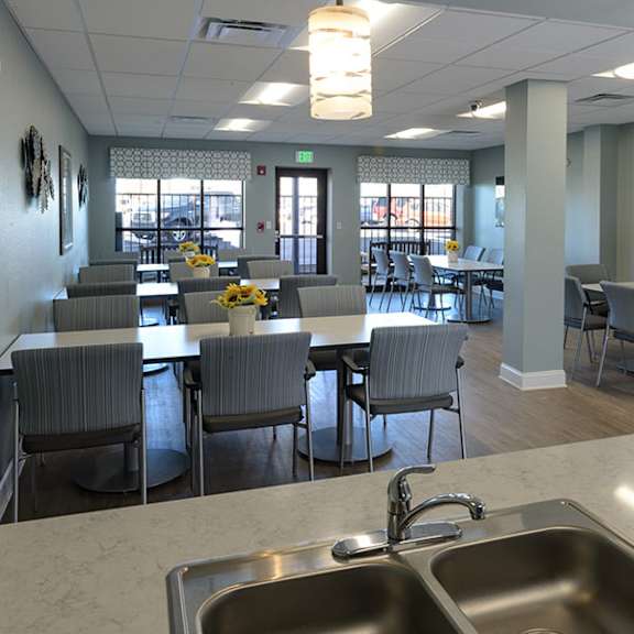 a dining room with grey chairs and tables.