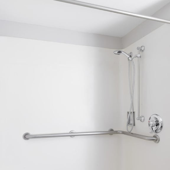 a white shower with a silver faucet and shower head.