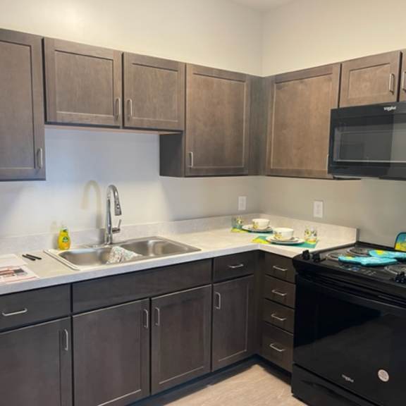a kitchen with brown cabinets and a black stove top oven.